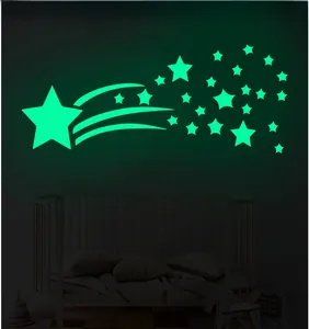 Luminous comet and star wall stickers glowing green in a dark bedroom setting