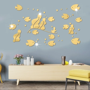 Detail of golden acrylic 3D fish mirror wall stickers on a modern blue living room wall