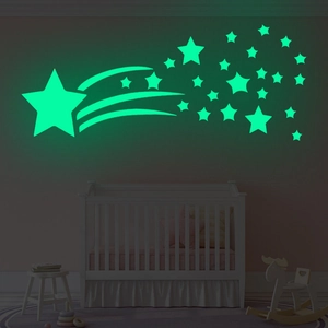 Luminous comet and star wall stickers glowing green in a cozy night nursery room decor