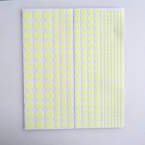 Detailed view of 2 sheets of circular luminous stickers in various sizes on white background