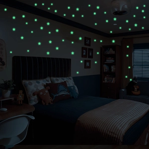 Luminous wall stickers showing glowing green stars and dots in a dark bedroom setting
