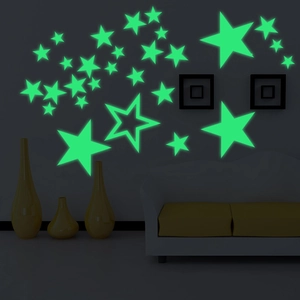 Detailed view of glow-in-the-dark stars wall stickers illuminating a dark living room