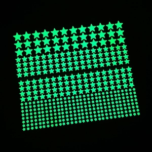 Glow in the dark star stickers in fluorescent green on dark background for wall decor