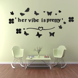 Close-up of 3D black acrylic wall stickers featuring 'her vibe is pretty' text and butterfly