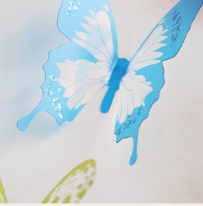 Primo piano dettagliato dell'adesivo murale farfalla 3D blu con accenti di glitter argento
