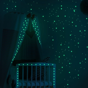 Luminous glow-in-the-dark star stickers applied to a baby crib in a dark bedroom