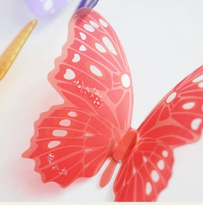 Vista macro dell'adesivo da parete a farfalla 3D arancione con glitter e macchie