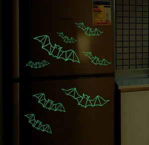 Luminous 3D geometric bat wall stickers glowing green on a dark surface in the dark