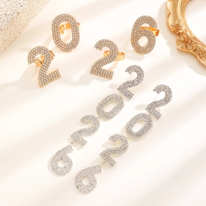 Detail van 2026 nummer oorbellen en ringen met fonkelende steentjes en gouden plating