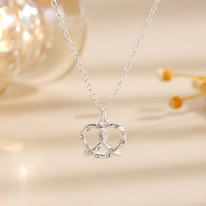 Dettaglio della collana con ciondolo a bretzel d'argento e pietre in zircone bianco