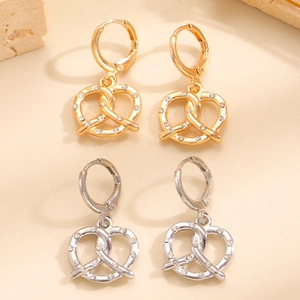 Dettaglio degli orecchini a forma di pretzel con cristalli lucidi in oro e argento