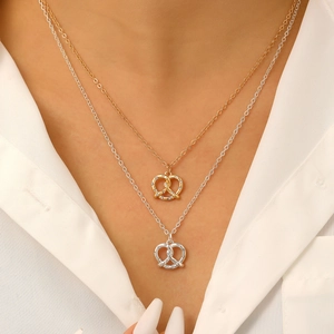 Collane a strati con nodi pretzel in oro e argento e zirconi indossate dalla modella