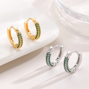 Detailed view of gold and silver hoop earrings featuring micro-paved green zircon stones