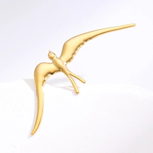 Broche hirondelle en or poli avec ailes profilées sur une base en pierre blanche