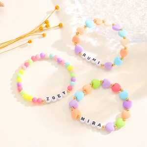 Detalle de las pulseras de cuentas coloridas K-POP con formas de corazón y nombres