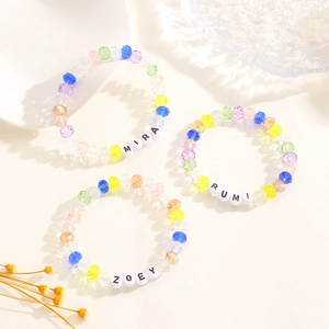 Vista macro detallada de cuentas facetadas de colores y letras personalizadas en pulseras