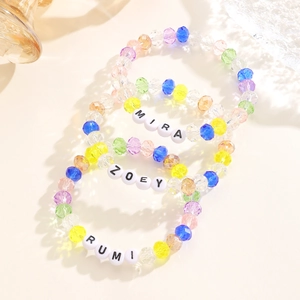 Detalle macro de cuentas de cristal facetadas coloridas y dijes de letras personalizados