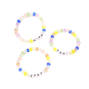 Detalle de cuentas de cristal de colores con colgantes de letras MIRA RUMI ZOEY