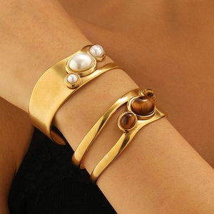 Detail view of 18k gold plated stainless steel cuff bracelet with brown tiger eye stones