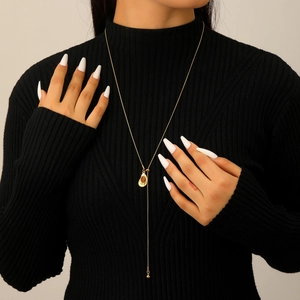 Close-up of golden Y-shaped tiger eye stone necklace on a black turtleneck sweater