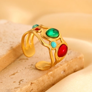 Macro-opname van gouden ring met zon en maan motief en gekleurde stenen op natuursteen