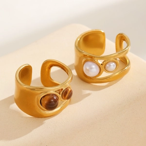 Detail of 18k gold plated stainless steel bangles with tiger eye and pearl stones