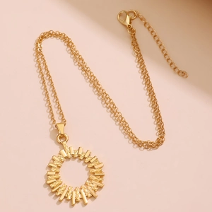 Macro shot of gold double-layer necklace with textured geometric circular pendant