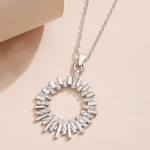 Detailed view of a silver-tone sunburst radial pendant with textured geometric layers
