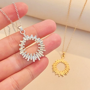 Close-up of gold and silver plated hollow round pendant with radial striped texture