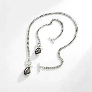 Dettaglio della collana a catena grumetta argento con gemme scure e chiusura a T