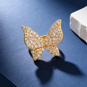 Elegant gold butterfly ring with zircon crystals on a deep blue textured surface