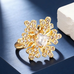 Macro shot of gold snowflake ring featuring sparkling zircons on a blue pedestal