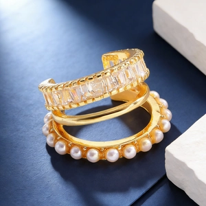 Detailed macro view of triple-layered gold ear cuff with zircon and pearl accents