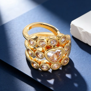Macro shot of gold wide band ring with center heart gemstone and sparkling zircons