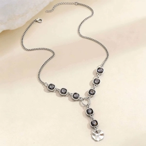Dettaglio della collana a Y argento con gemme nere quadrate e ciondolo tondo inciso