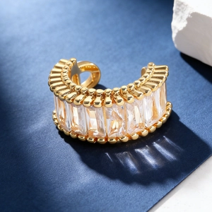 Close-up of gold ear cuff featuring rectangular zircons and delicate beaded edges