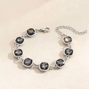 Dettaglio di bracciale in argento con otto pietre nere quadrate e chiusura a moschettone