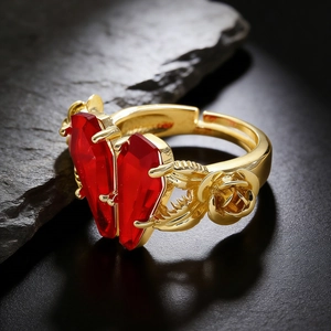 Macro view of gothic gold ring featuring red coffin gems and carved rose details