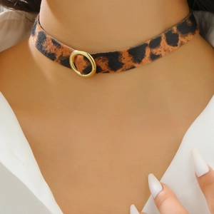 Close-up of leopard print velvet choker necklace with a central golden metal ring
