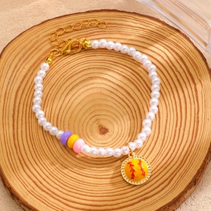 Vue détaillée du bracelet de perles avec pendentif de baseball sur plateau en bois