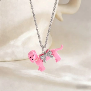 Detailaufnahme des rosa Emaille-Dackelanhängers mit Diamantschleife an silberner Kette