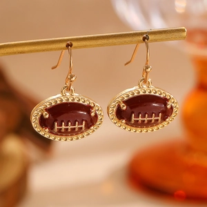 Détail de boucles d'oreilles football américain en métal doré et émail rouge foncé