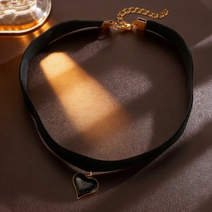 Close-up of black velvet heart choker with silver glitter detail and golden hardware