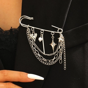 Détail d'une broche épingle argentée avec breloques cœur et étoile et chaînes multicouches