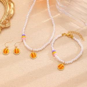 Détails d'un ensemble de bijoux en perles avec breloques de softball sur fond élégant