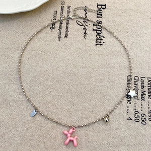 Dettaglio della collana di perline con ciondolo a cane palloncino rosa e stella argento