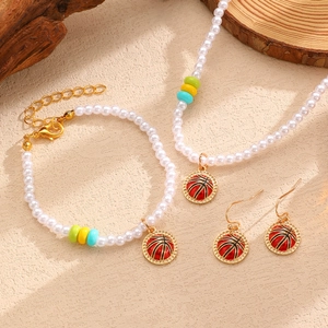 Détail d'un ensemble de bijoux avec pendentifs basket émaillés et perles blanches