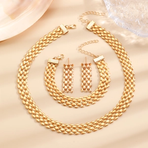 Flat lay of gold plated layered necklace and bracelet set with woven mesh texture