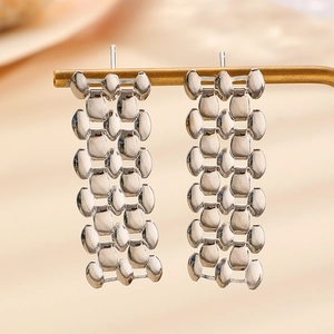 Detailed macro view of wide silver-toned chain link earrings with high polish finish