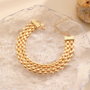Detail of gold woven multi-layer bracelet with adjustable lobster clasp and chain